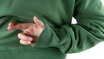 Una persona cruzando los dedos detrás de su espalda