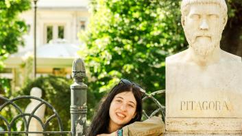 Una mujer posa junto a un busto de Pitágoras