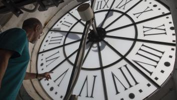 Un hombre cambia la hora en el reloj de una iglesia de Buñola, en Baleares.