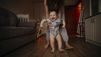 Un bebé y su madre andan descalzos por casa