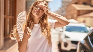 Mujer joven se refresca con un abanico