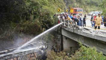 Fotografía cedida por Bomberos Cuenca que muestra a sus integrantes atendiendo el accidente de un autobús que se precipitó a un abismo y posteriormente se incendió, el 16 de abril de 2026, en Ecuador.