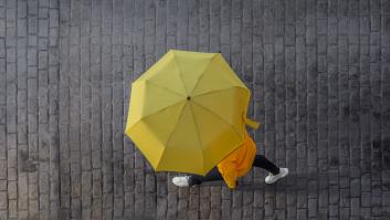 Una mujer camina con un paraguas