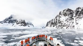 Un barco lleno de gente atravesando la congelada Antártida