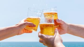 Varias personas beben cerveza en una playa.