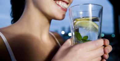 Persona bebiendo agua con limón, una práctica habitual vinculada a mitos sobre nutrición y bienestar.