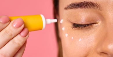 Un mujer aplicándose contorno de ojos