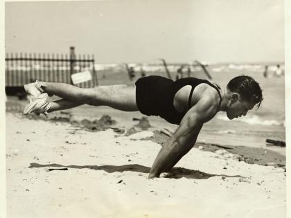 Man doing pushups on the sands of the beach. He is on his hands while his feet are elevated. (Photo by George Rinhart/Corbis via Getty Images)