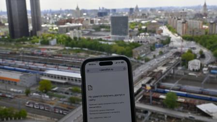 Pantalla de un teléfono móvil que muestra problemas para acceder a Internet móvil con la ciudad de Moscú en el fondo.