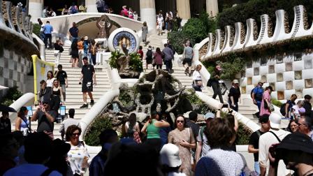 Una masificación de turistas visitando la escalera monumental del Parque Güell de Barcelona