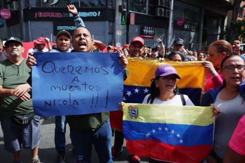 Simpatizantes del oficialismo sostienen carteles en inmediaciones del Palacio de Miraflores este sábado, en Caracas (Venezuela). Chavistas salieron a las calles del centro de Caracas para exigir que "devuelvan" al mandatario venezolano, Nicolás Maduro, luego de que el líder estadounidense, Donald Trump, anunciara la captura del gobernante suramericano en medio de un ataque con misiles durante la madrugada de hoy contra la capital venezolana y otras zonas del país.