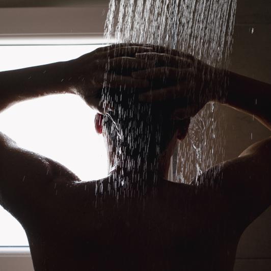 Primer plano de un joven en la ducha.