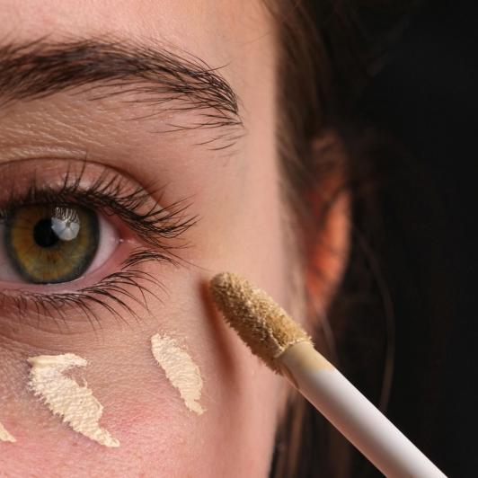Una mujer aplicándose corrector