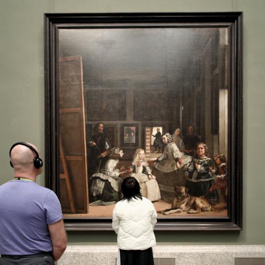 Dos personas mirando 'Las Meninas' en el Museo del Prado.