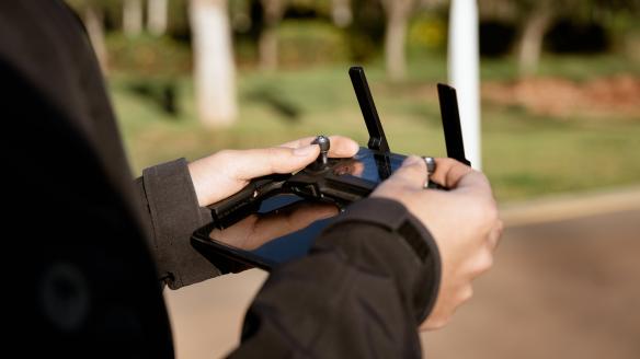 Una persona controlando un dron mediante un joystick.