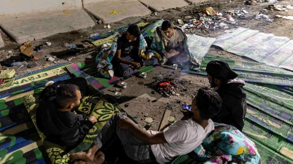 Refugiados palestinos aguardan en un campamento improvisado al borde de la frontera egipcia, el paso de Rafah, por donde se enviarán 20 camiones de ayuda humanitaria, cuando la ONU reclama 100 diarios.