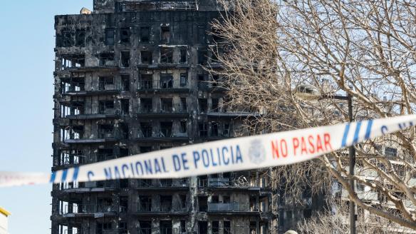 Una cinta policial impide el paso hacia los edificios afectados por un incendio ayer jueves en València, en el que de momento se contabilizan cuatro víctimas mortales, a falta de poder acceder al interior de la estructura, mientras que las personas no localizadas se sitúan en estos momentos en 14, aunque esta cifra puede ir variando conforme prosigan las investigaciones.