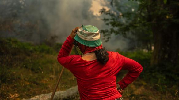 A Pobra de Trives (Ourense), 13/08/2025.- Una vecina de la aldea de Pareisás lucha contra en fuego en el incendio forestal que permanece activo en A Pobra de Trives (Ourense). EFE/Brais Lorenzo