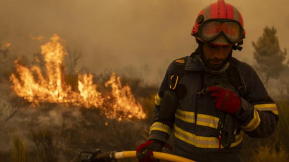 Vecinos y bomberos intentan aplacar el fuego que afecta este viernes a la aldea de Lamas (Cualedro), en Ourense.