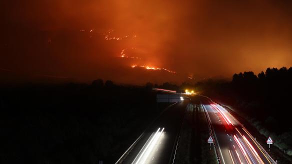 Vista de la A-52 en la madrugada de este domingo, en Orense (Galicia) con un incendio cercano a la carretera.