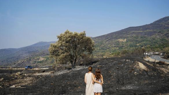 Dos mujeres observan un área calcinada en la localidad cacereña de Cabezabellosa por el incendio de Jarilla (Cáceres), un fuego que también entró en Castilla y León.
