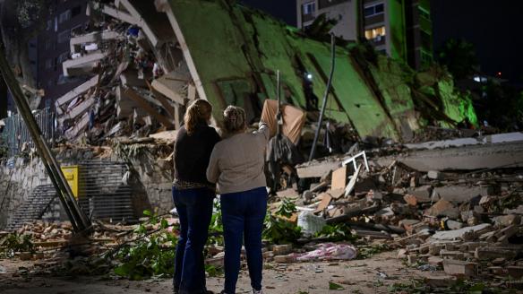 Fanny Nasri espera en el lugar del derrumbe de un edificio mientras los equipos de emergencia buscan a su hijo, Antonio Nasri, junto a Noemi Córdoba, quien espera noticias de su nieta, tras el terremoto en Caracas.