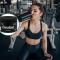 Una mujer bebe un batido en un gimnasio; sobre un círculo, el nuevo bote de creatina disponible en Mercadona