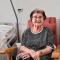Una anciana recostada en una butaca junto a una cama de hospital mira sonriente a cámara: es Rosita Rochina
