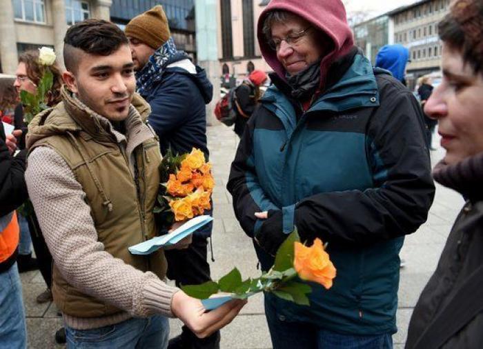 Grupos de refugiados regalan flores a los ciudadanos tras las agresiones a mujeres en Alemania