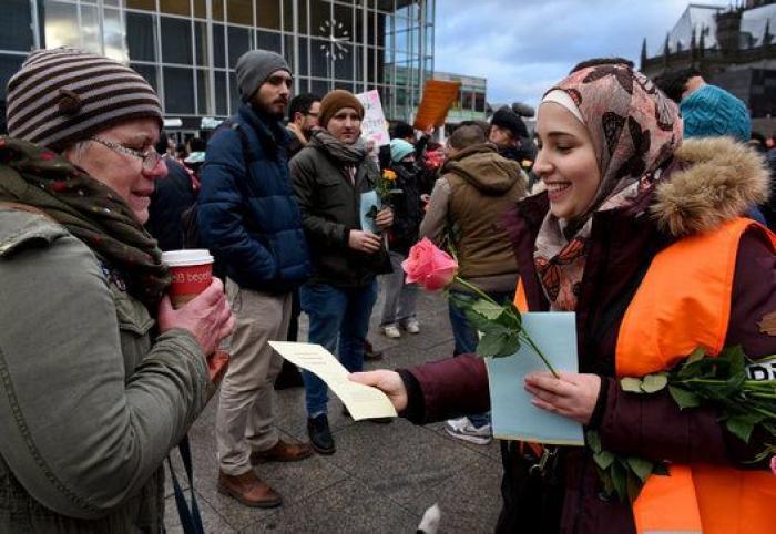 Grupos de refugiados regalan flores a los ciudadanos tras las agresiones a mujeres en Alemania