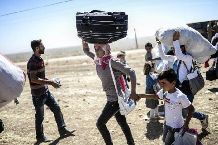 Las duras imágenes de 60.000 kurdos cruzando la frontera con Turquía (FOTOS)