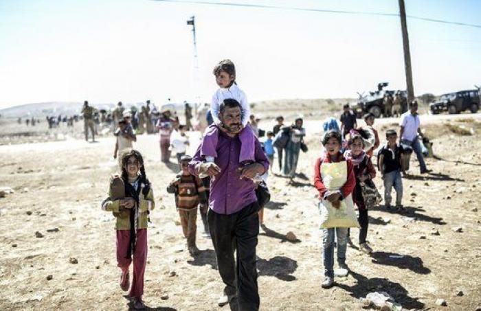 Las duras imágenes de 60.000 kurdos cruzando la frontera con Turquía (FOTOS)