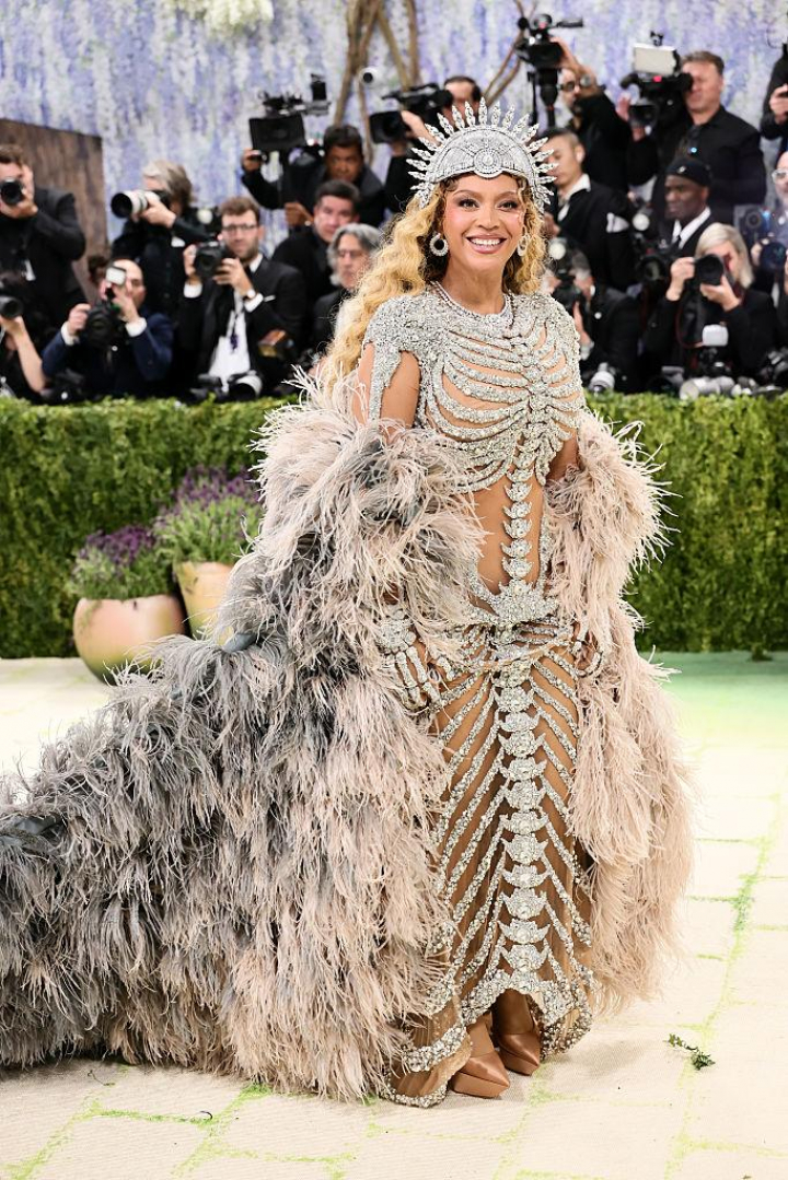 alt="alt="Diez años después, la estrella ha vuelto a la Gala Met con este diseño en forma de esqueleto de Olivier Rousteing acompañado con una larguísima capa de plumas degradada.""