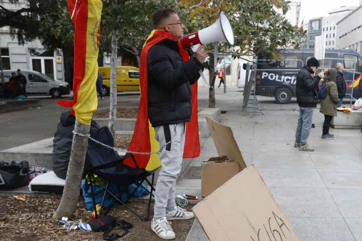El hombre que se ha encadenado al árbol recita consignas con un megáfono como "qué te vote Txapote".