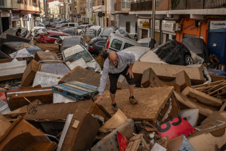 Un hombre camina por una calle de Utiel cubierta de escombros después de que las inundaciones repentinas provocadas por el paso de una DANA.