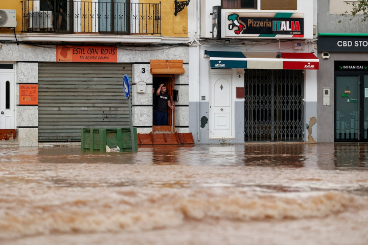 Un vecino e Llombai, en Valencia, observa con preocupación la crecida del agua que ha causado la DANA que ha afectado al sur y este de España.