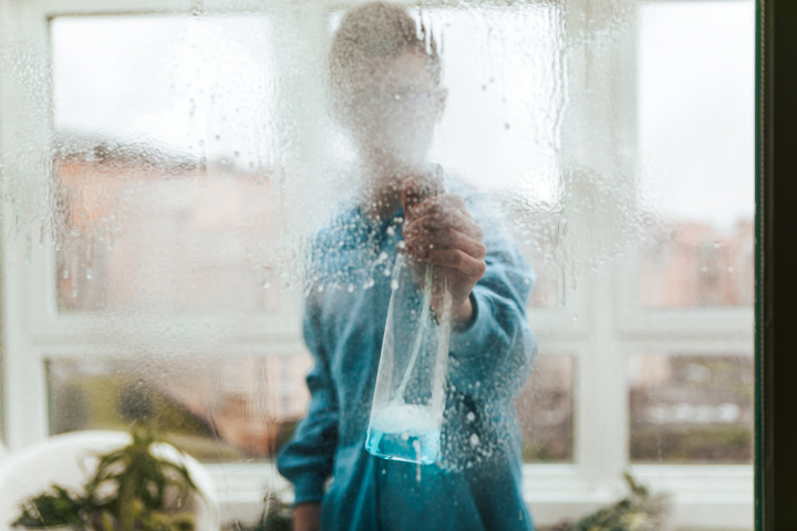 Una persona limpia un cristal.