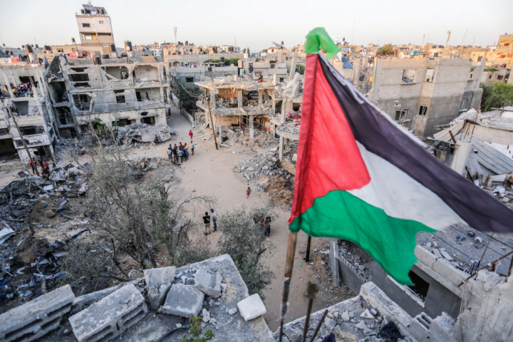 Bandera palestina en lo alto de un edificio en una zona de Gaza devastada por las bombas