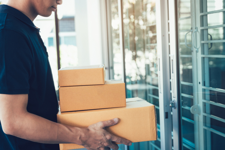 Un cartero entrega un paquete en una casa.