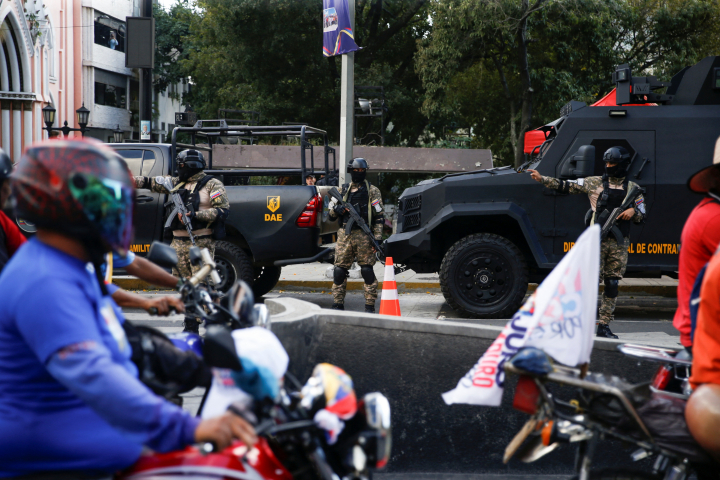 Oficiales de la dirección general militar de contrainteligencia (DGCIM) controlan uno de los 'checkpoints' habilitado en las carreteras de Caracas, bajo la mirada de integrantes de las brigadas chavista motorizadas, grupo afín al PSUV.