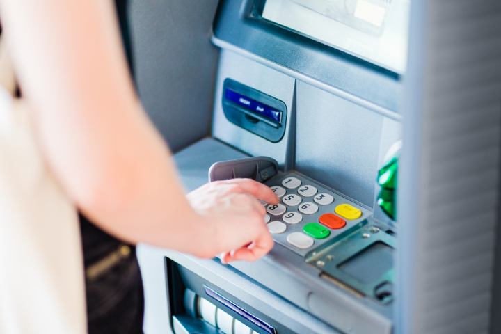 Una persona sacando dinero de un cajero automático.