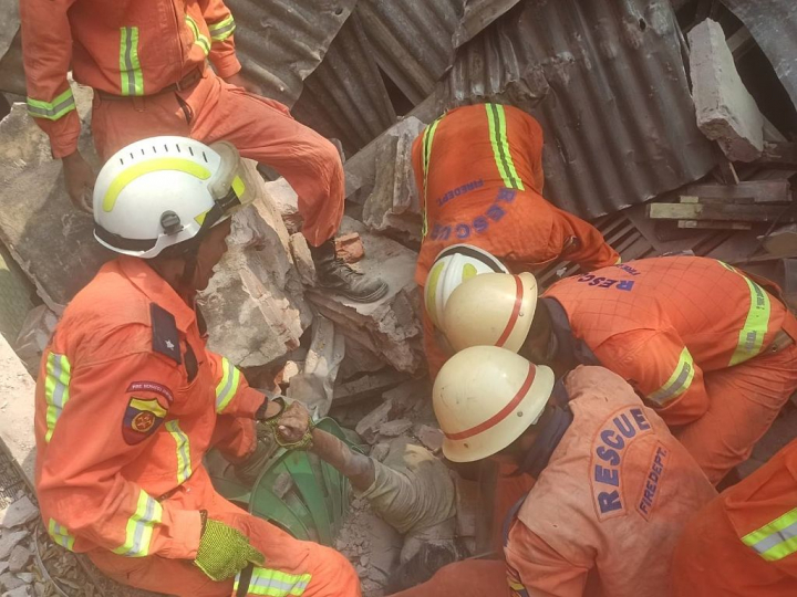 alt="alt="Operadores del Servicio de bomberos de Myanmar rescatan el cuerpo de una víctima.""
