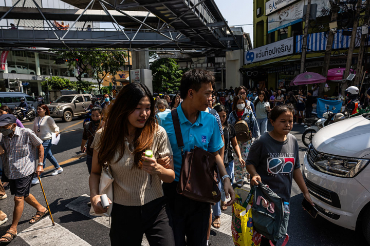 alt="alt="Un grupo de personas corre hacia un lugar seguro durante el movimiento provocado por el terremoto de magnitud 7,7 que ha sacudido Birmania y Tailandia.""