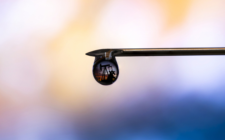 Ilustración de una refinería reflejada en una gota de petróleo.