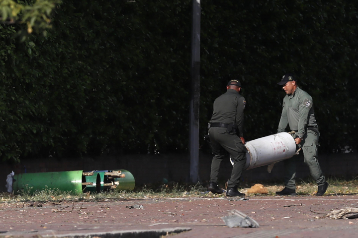 Policías colombianos mueven varios cilindros hallados en la zona del atentado