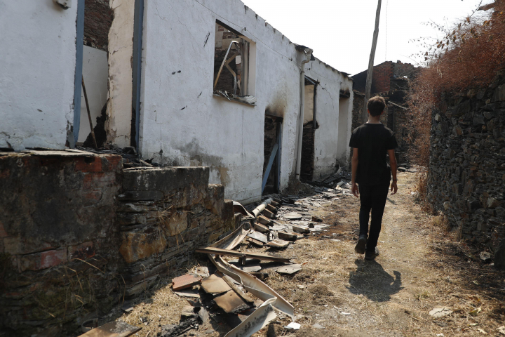 Un joven camina por una de las calles de Ferreira, una aldea en Lugo afectada por las llamas.