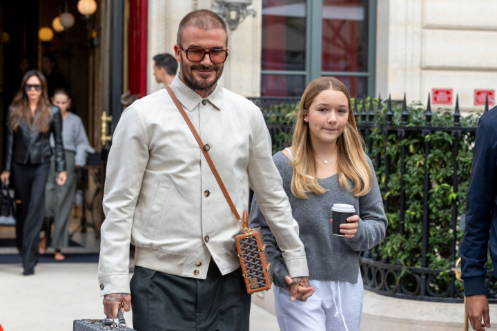 David Beckham y su hija Harper Beckham en París. Él lleva un bolso maletín de Goyard.