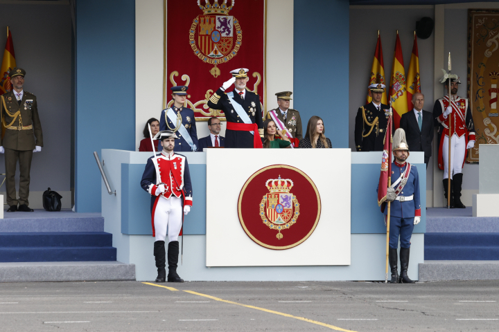 Felipe VI y la princesa Leonor de pie en el desfile militar del 12 de octubre mientras Letizia la infanta Sofía permanecen sentadas