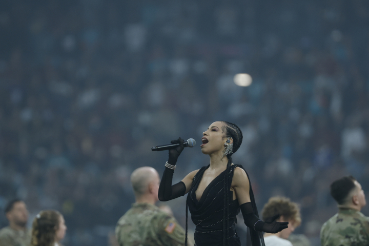 alt="alt="La cantante Karina Pasian canta el himno estadounidense durante el partido de liga regular de la Liga de Fútbol Americano (NFL), que disputan los equipos Miami Dolphins y Washington Commanders, este domingo en el Estadio Santiago Bernabéu.""