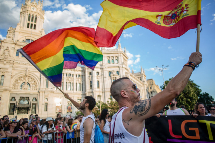 La bandera del orgullo LGTBIQ+, junto a la bandera de España.